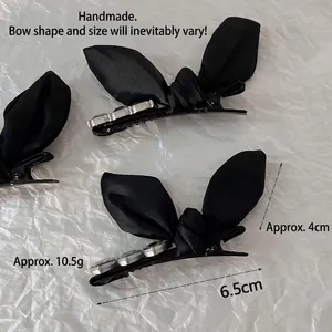 Elegant black satin bow hair clip with crystal heart detail and silver duckbill clip