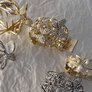 Détails de pinces à cheveux dorées et argentées avec motifs papillon et perles nacrées