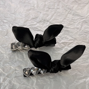 Elegant black bow hair clips set with heart and rectangular grey crystals on white background