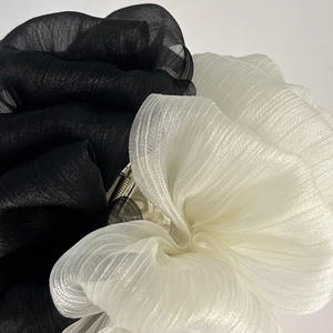 Détail d'une pince à cheveux à nœud en organza noir et blanc avec couches de tissu élégantes