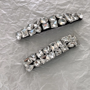 Gros plan détaillé de barrettes à strass étincelants sur un fond argenté texturé de luxe