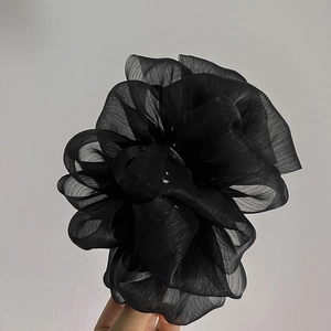 Détail de la grande pince à cheveux fleur en organza noir avec tissu voilage multicouche