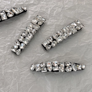 Vue détaillée de quatre barrettes à strass avec cristaux géométriques sur fond gris