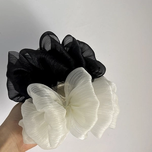 Gros plan détaillé de grands chouchous en organza noir et beige à texture plissée