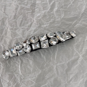 Détail montrant diverses formes de cristaux et strass sur une pince à cheveux de qualité