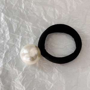 Detailed view of high elasticity black hair tie featuring a large glossy cream pearl bead
