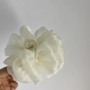Détail de la pince à cheveux en organza crème montrant la texture plissée vaporeuse