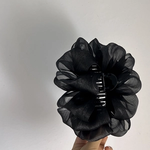 Détail d'une pince à cheveux fleur en organza noir avec des pétales multicouches
