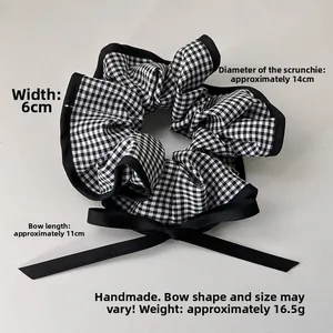 Detail view of checkered scrunchie showing 14cm diameter and 11cm bow dimensions