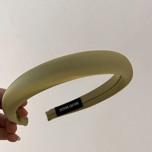Detailed shot of handmade padded sponge headband in bean green satin with inner label