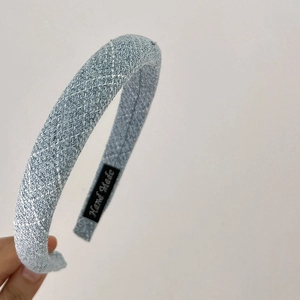 Detailed shot of quilted light blue denim headband with Hand Made woven label inside