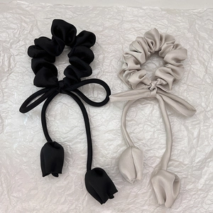 Détail de chouchous en satin avec nœuds élégants et breloques de tulipes
