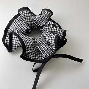 Classic black and white checkered scrunchie with elegant black ribbons for hair styling