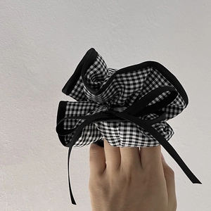 Chic black and white gingham scrunchie with a delicate black ribbon bow and piping