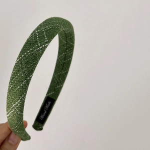 Detail showing high crown fabric headband with white diamond stitching and handmade label