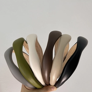 Close-up of sheepskin-like wavy sponge headbands in diverse neutral and earthy colors