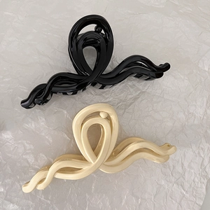 Grandes pinces à cheveux ondulées noir et blanc crème pour une coiffure élégante