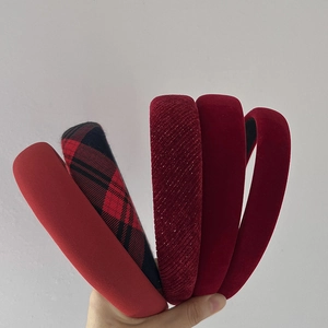 Detailed view of assorted red velvet and plaid headbands with rich textures and colors