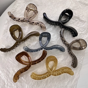 Flat lay of seven large jelly color shark hair claws in assorted tortoise and resin finishes