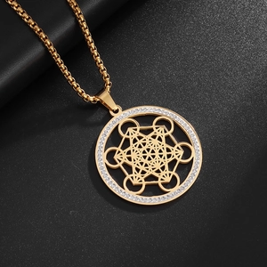 Close-up of golden Metatron's Cube pendant with sparkling rhinestones on black background