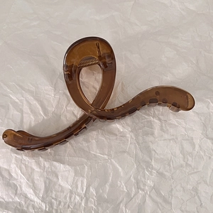 Detailed view of amber translucent acrylic hair claw clip with a strong metal spring