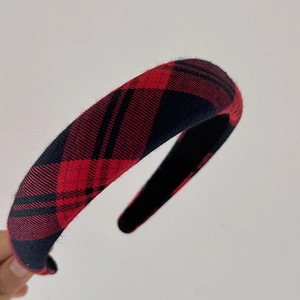 Close-up detail of the vintage red and black tartan plaid padded headband with fabric texture