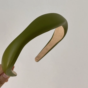 Detail of olive green faux leather headband with sponge padding and beige lining