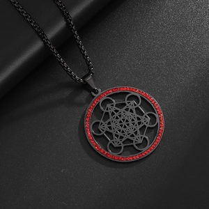Macro shot of black Metatron's Cube pendant with red rhinestones on dark textured background