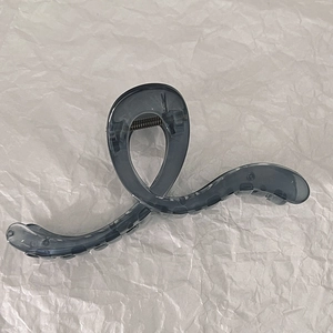 Macro detail of large translucent smoke gray hair claw clip with strong metal spring