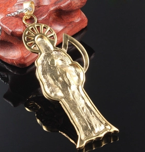 Détail du pendentif Santa Muerte doré avec dos texturé et chaîne en corde argent