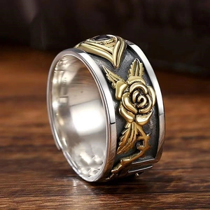 Makroaufnahme des Silberrings mit goldenem Rosenrelief und Auge des Horus Motiv