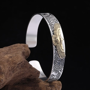 Bracelet vintage en argent avec aigle doré et gravures florales sur bois rustique