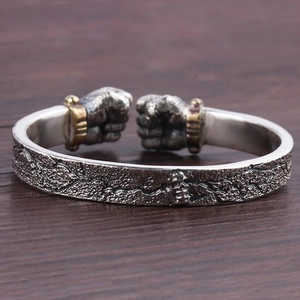 Retro punk fist open bangle with silver skull relief and rock texture on wood base