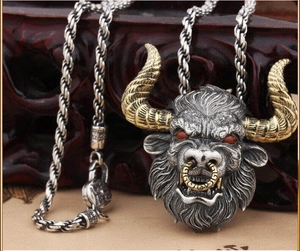 Vue détaillée du pendentif tête de taureau gothique avec cornes dorées et yeux rouges