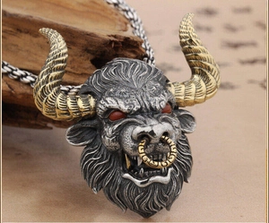 Détail du pendentif tête de taureau vintage avec cornes dorées et yeux rouges sertis