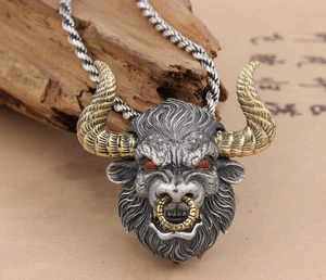 Gros plan du pendentif tête de taureau rétro avec cornes dorées et texture argentée