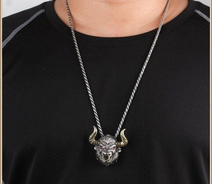 Gros plan d'un pendentif tête de taureau vintage avec cornes dorées sur un homme