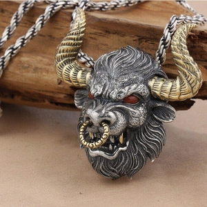 Pendentif tête de taureau vintage avec cornes dorées et yeux rouges sur fond en bois