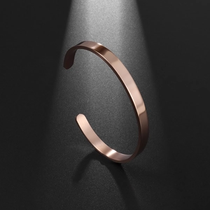 Detailed view of minimalist rose gold stainless steel open cuff bracelet with polished finish