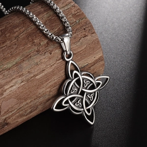 Close-up of silver steel Celtic Witch's Knot pendant on wooden stump with a box chain