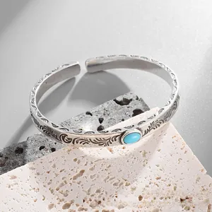 Close-up of vintage engraved silver cuff bracelet featuring a turquoise stone inlay