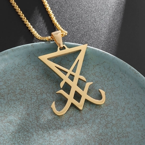 Gros plan du pendentif sceau de Lucifer en or 18K sur une chaîne box dans un plateau bleu