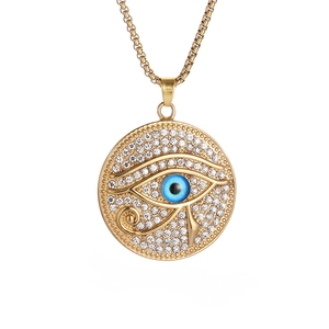 Détail du pendentif Œil d'Horus doré serti de strass blancs et d'un œil bleu central