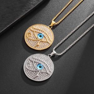 Pendentifs Hip Hop Oeil d'Horus en or et argent avec cristaux sur fond noir mat