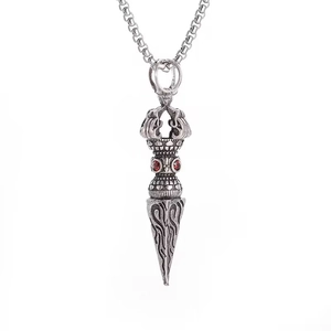 Détail macro du pendentif Phurba vintage avec pierres rouges et texture argent antique
