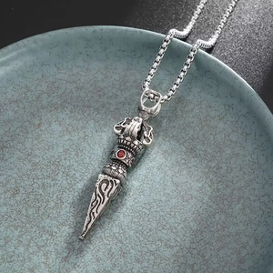 Détail du pendentif Vajra avec pierre rouge et gravures de nuages sur chaîne box