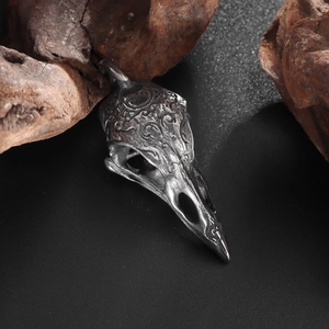 Vue macro d'un pendentif crâne d'oiseau gravé sur un fond de bois rustique foncé