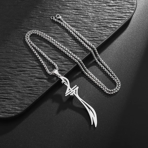 Detailed close-up of a silver stainless steel Zulfiqar sword pendant on a textured surface