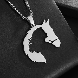 Detail of silver hollowed horse head pendant on a round box chain over black leather