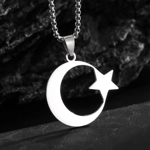 Vue macro du pendentif lune et étoile en acier inoxydable poli sur une chaîne à billes